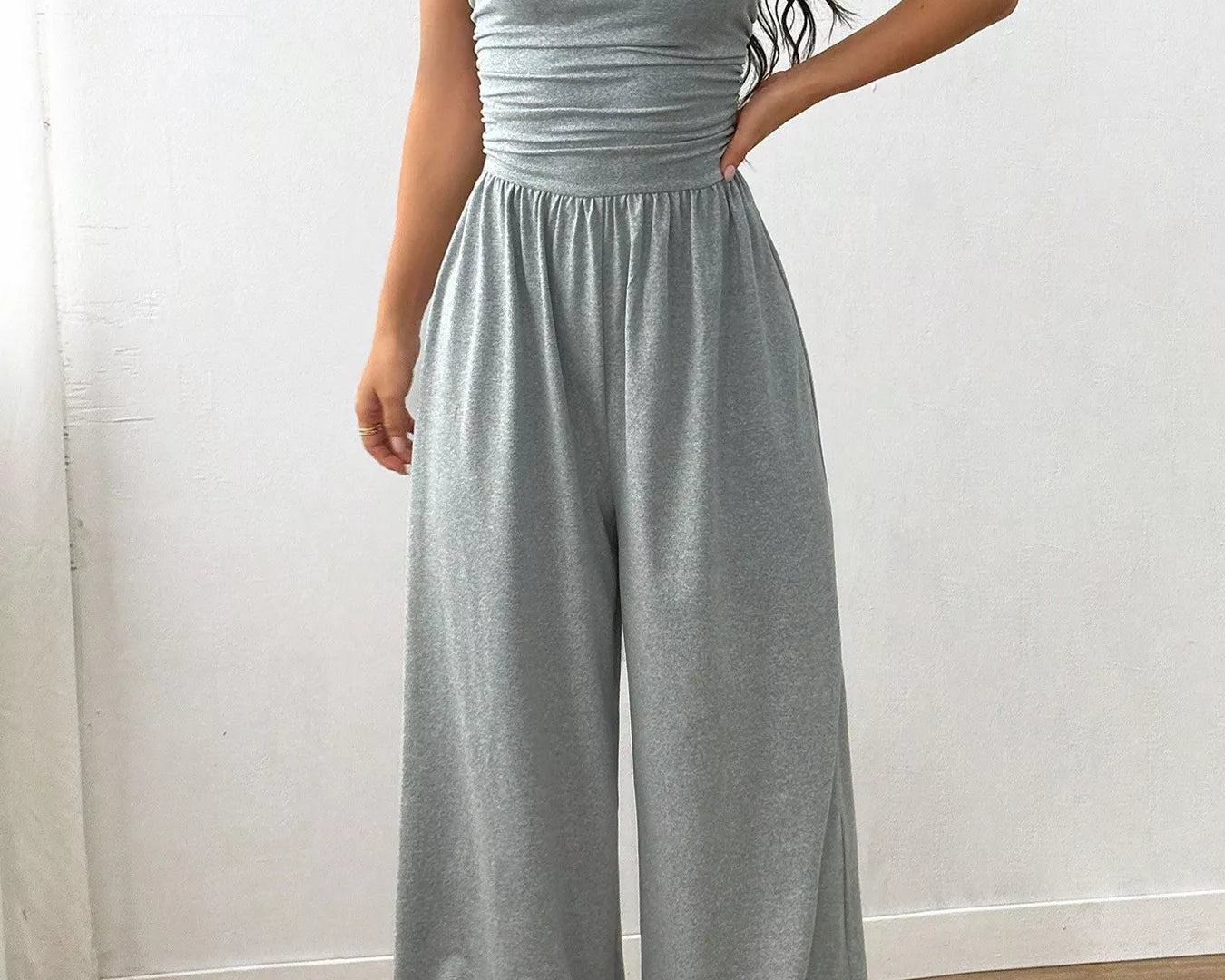 NEWYORKLISTED Comfort Collection: Woman wearing a gray jumpsuit against a white background