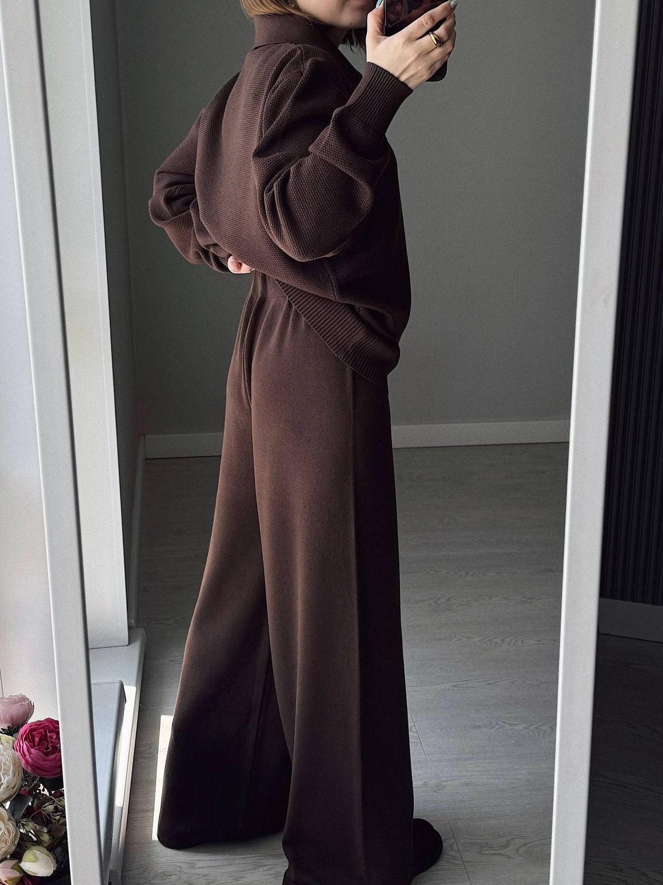 NEWYORKLISTED Comfort Collection: Person wearing a brown outfit standing in front of a mirror.