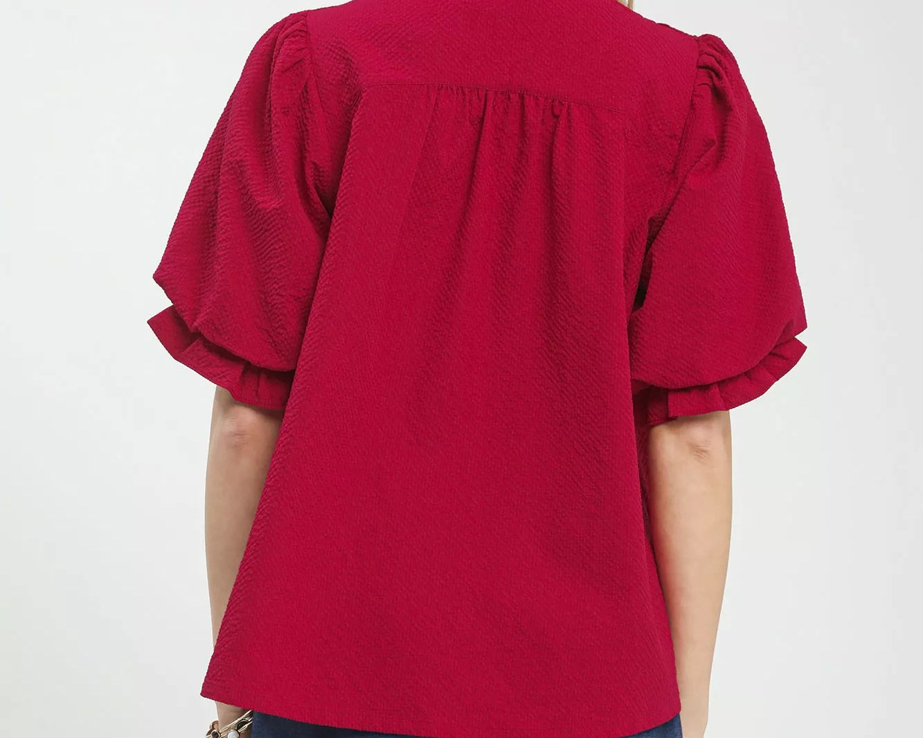 NEWYORKLISTED Style Collection: Red blouse with ruffled sleeves worn by a person on a white background
