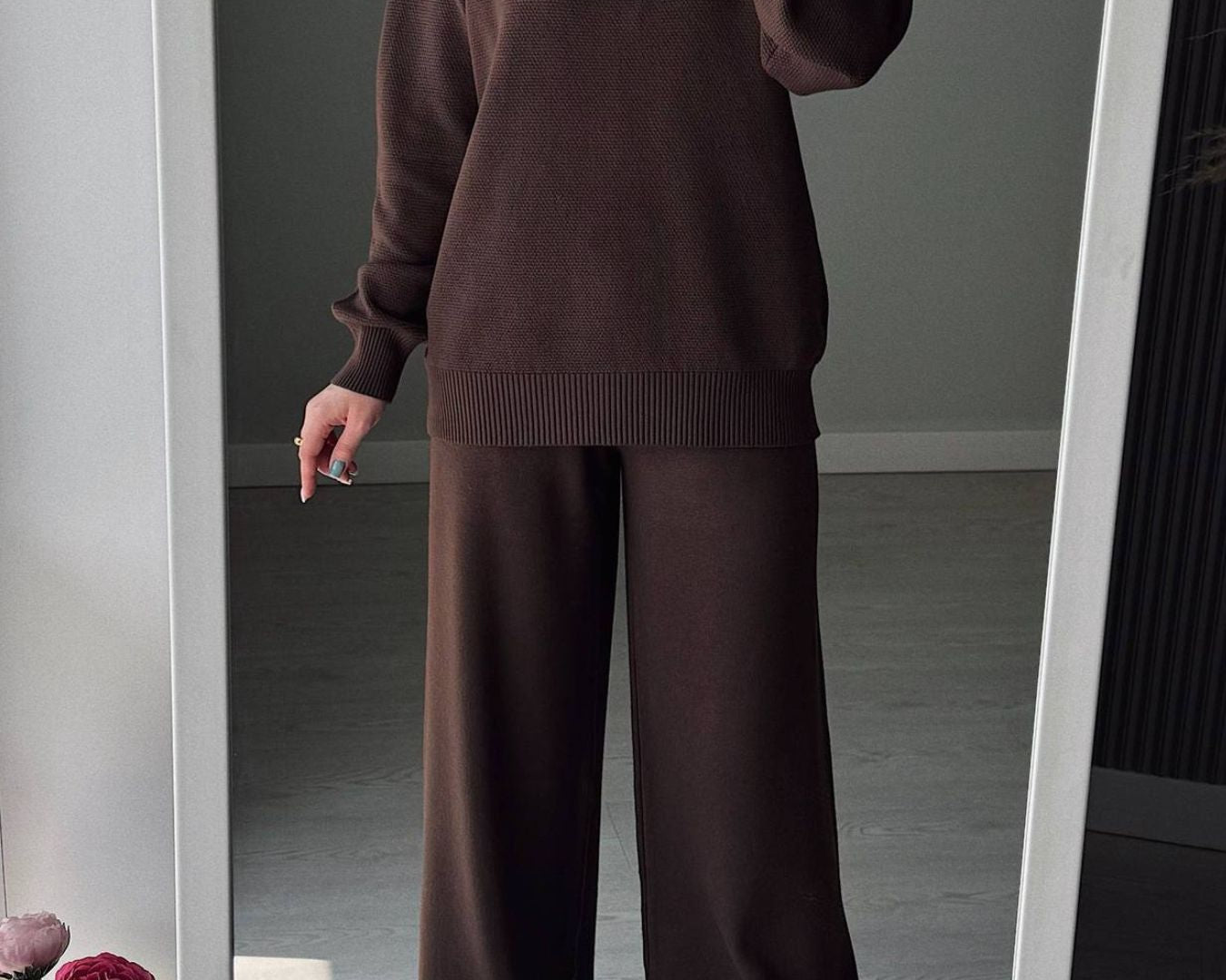 NEWYORKLISTED Comfort Collection: Person wearing a brown sweater and pants standing in front of a mirror.