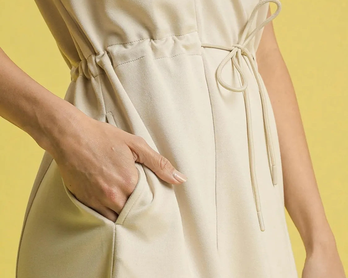 NEWYORKLISTED STYLE COLLECTION: Short Sleeve Midi Tee Dress Beige jumpsuit worn by a person on a yellow background