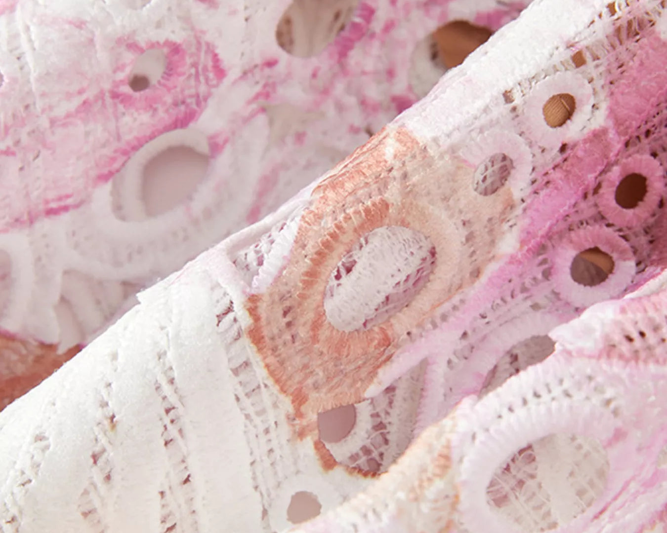 NEWYORKLISTED STYLE COLLECTION: Close-up of pink and white lace fabric with intricate patterns.