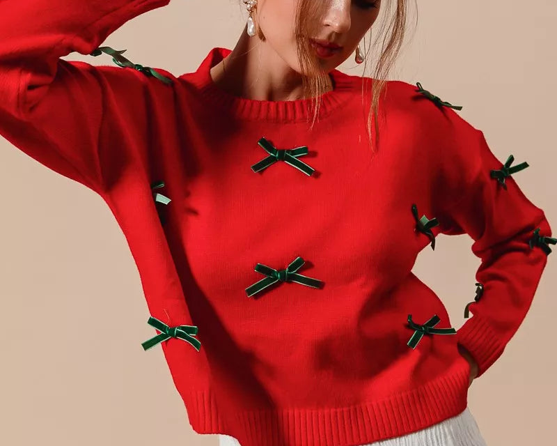 NEWYORKLISTED STYLE COLLECTION: Woman wearing a red sweater with green bows on a beige background