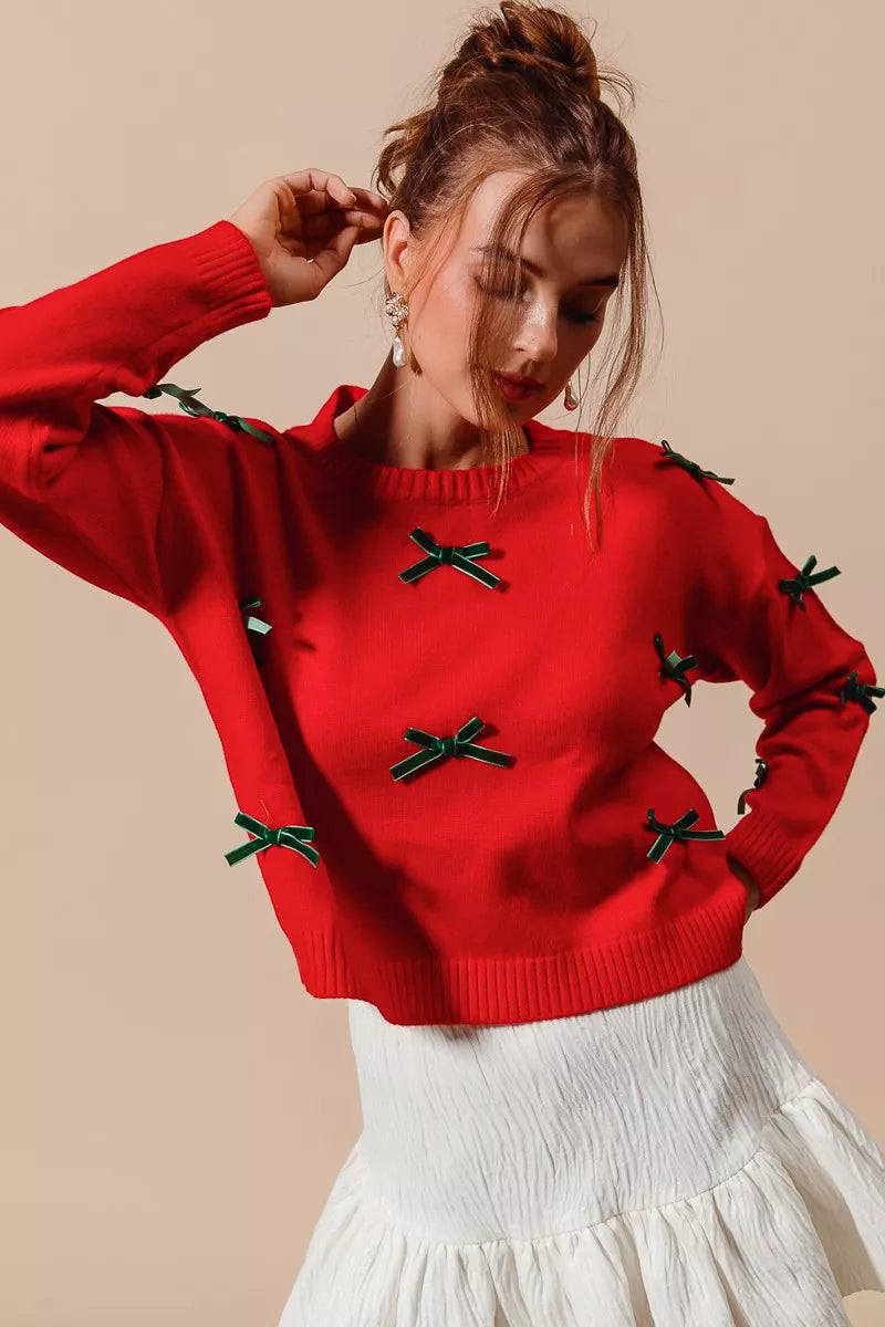 NEWYORKLISTED STYLE COLLECTION: Woman wearing a red sweater with green bows on a beige background