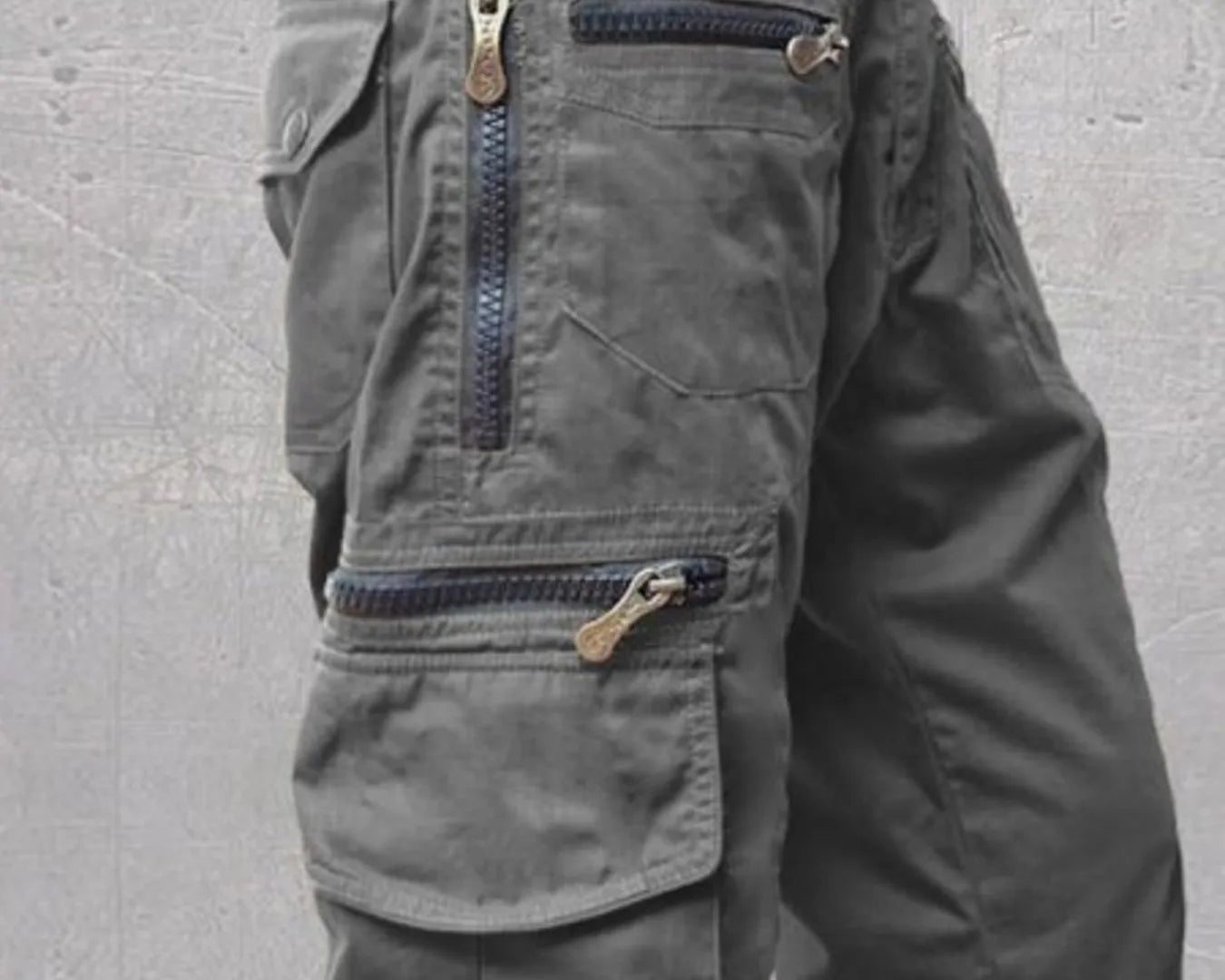 NEWYORKLISTED ATLAS MEN'S COLLECTION: Gray cargo shorts with multiple pockets and zippers on a gray background
