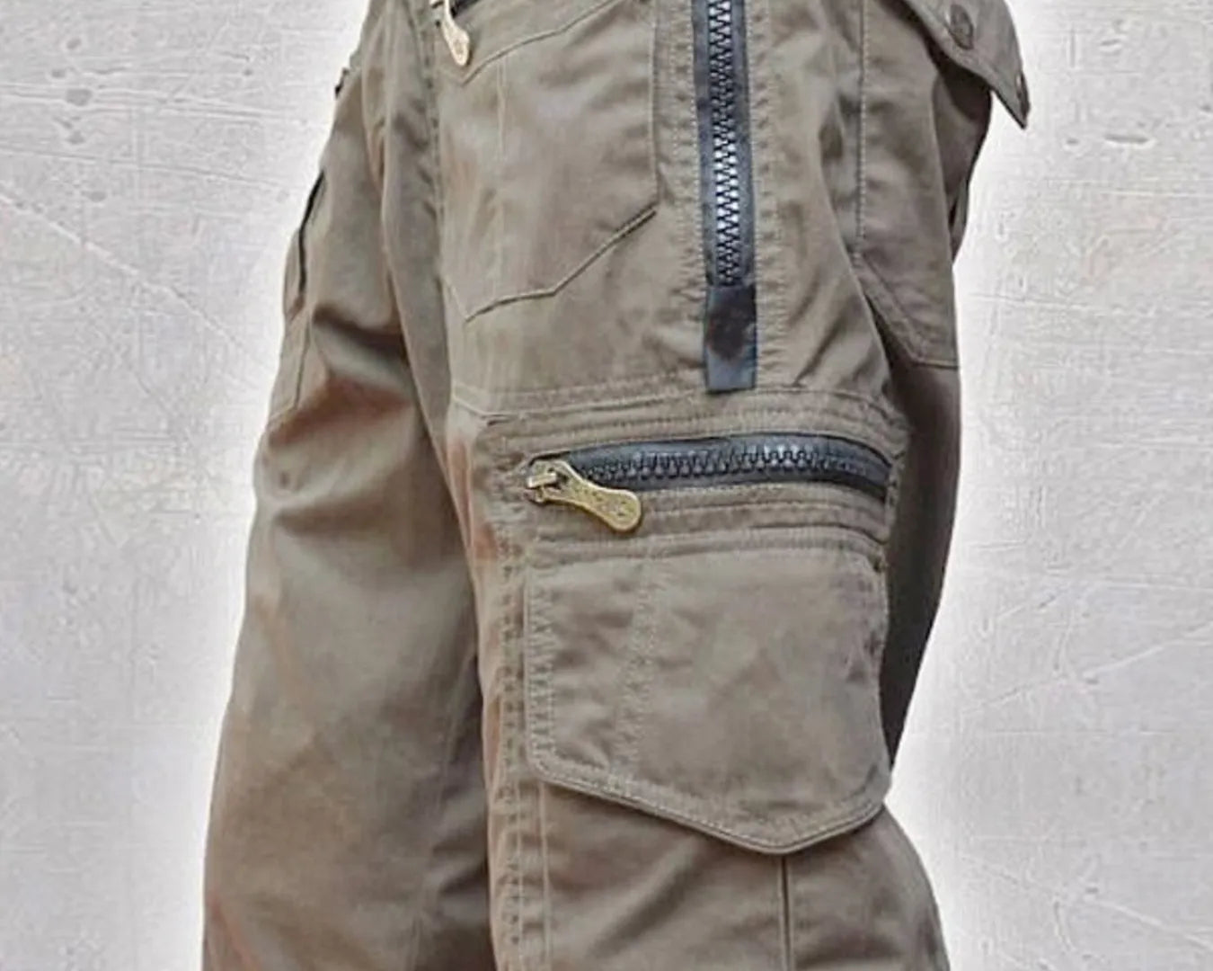 NEWYORKLISTED ATLAS MEN'S COLLECTION: Khaki cargo shorts with zippers on a light gray background