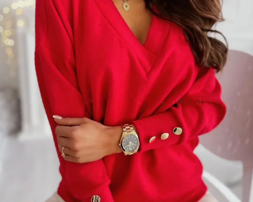 NEWYORKLISTED STYLE COLLECTION: Woman wearing a red sweater with gold buttons in an indoor setting