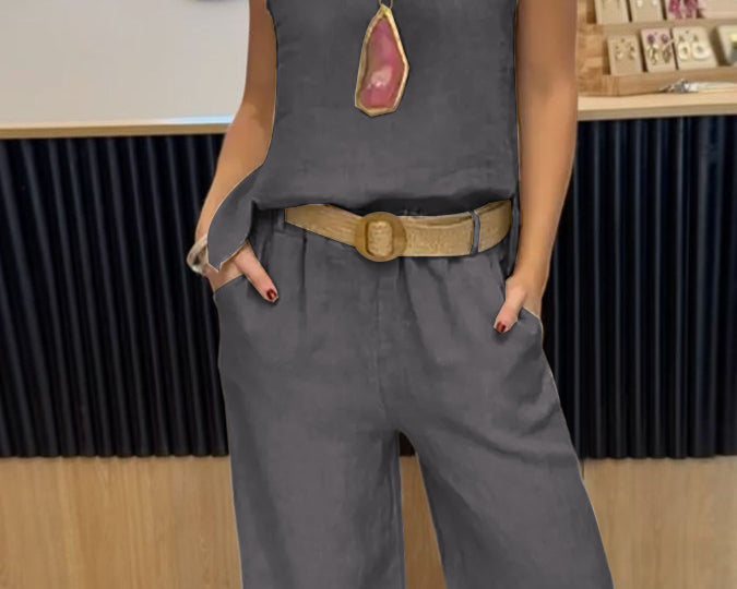 NEWYORKLISTED COMFORT COLLECTION: Person wearing a gray sleeveless top and pants with a belt, standing indoors.
