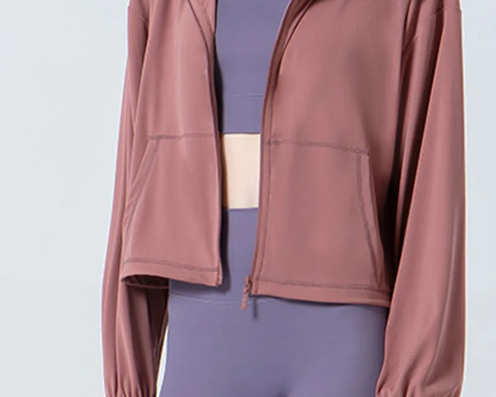 NEWYORKLISTED ACTIVEWEAR COLLECTION: Person wearing a mauve jacket over a purple athletic outfit on a light gray background