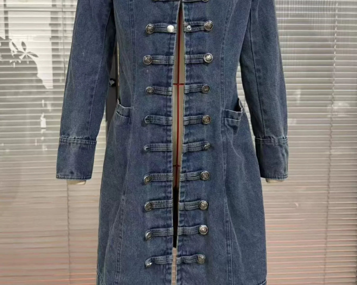NEWYORKLISTED STYLE COLLECTION – Women's long blue denim military-style jacket featuring decorative gold buttons, structured collar, tailored silhouette, and long sleeves, styled with a white button-down shirt and blue jeans.