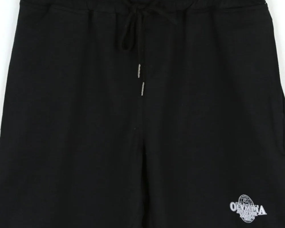NEWYORKLISTED ATLAS MEN's COLLECTION: Black shorts with a logo on a hanger against a white background