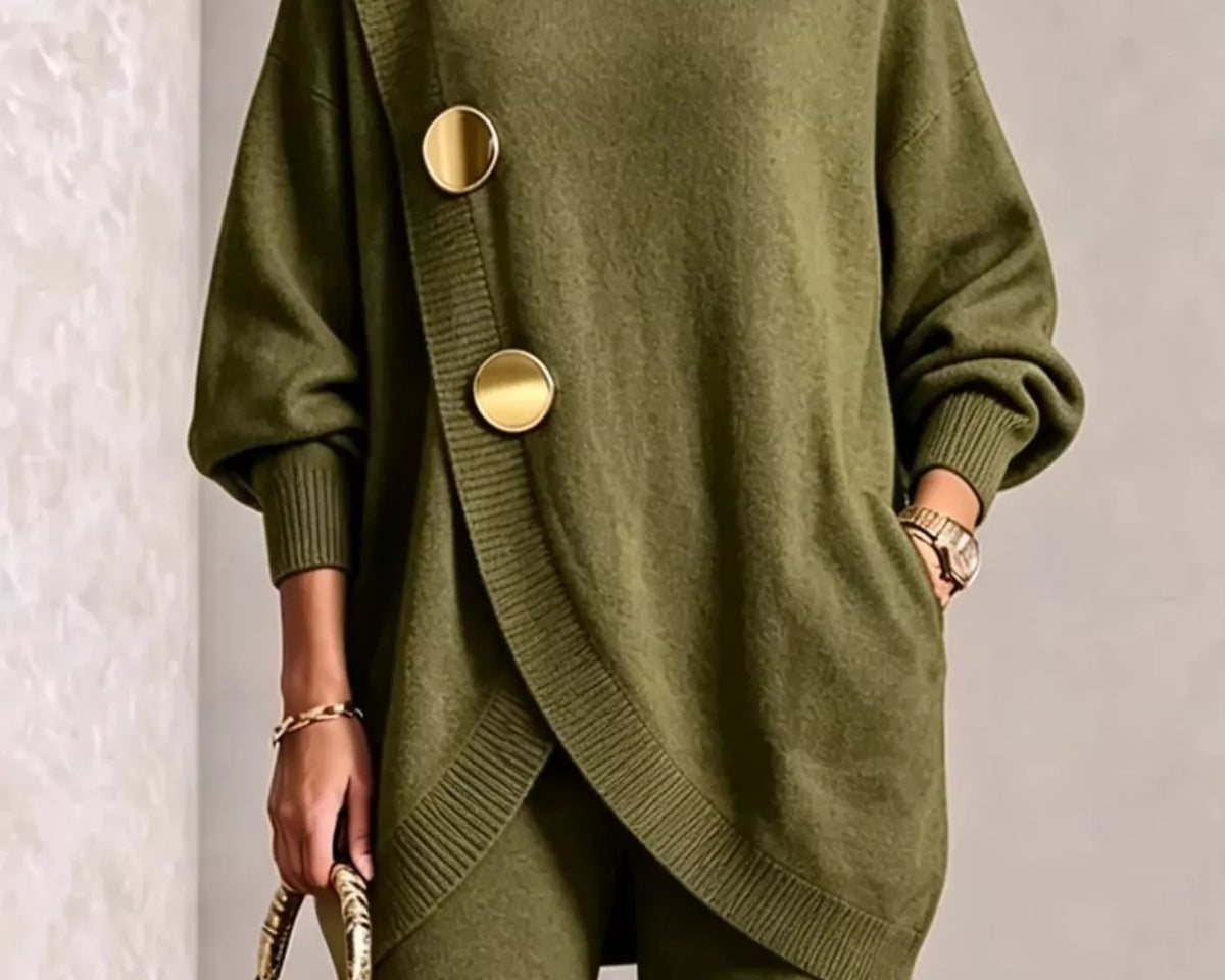 NEWYORKLISTED STYLE COLLECTION: A woman models an olive green knit turtleneck sweater with oversized decorative gold buttons and matching wide-leg knit pants, holding a small metallic gold handbag against a neutral textured wall.