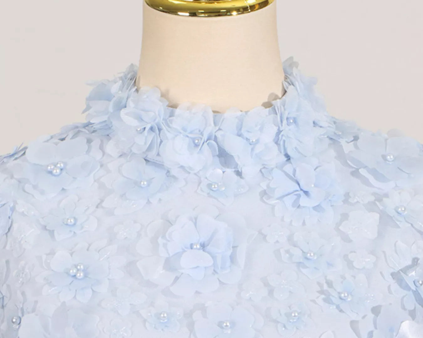 NEWYORKLISTED STYLE COLLECTION: Light blue floral dress on a mannequin with a white background