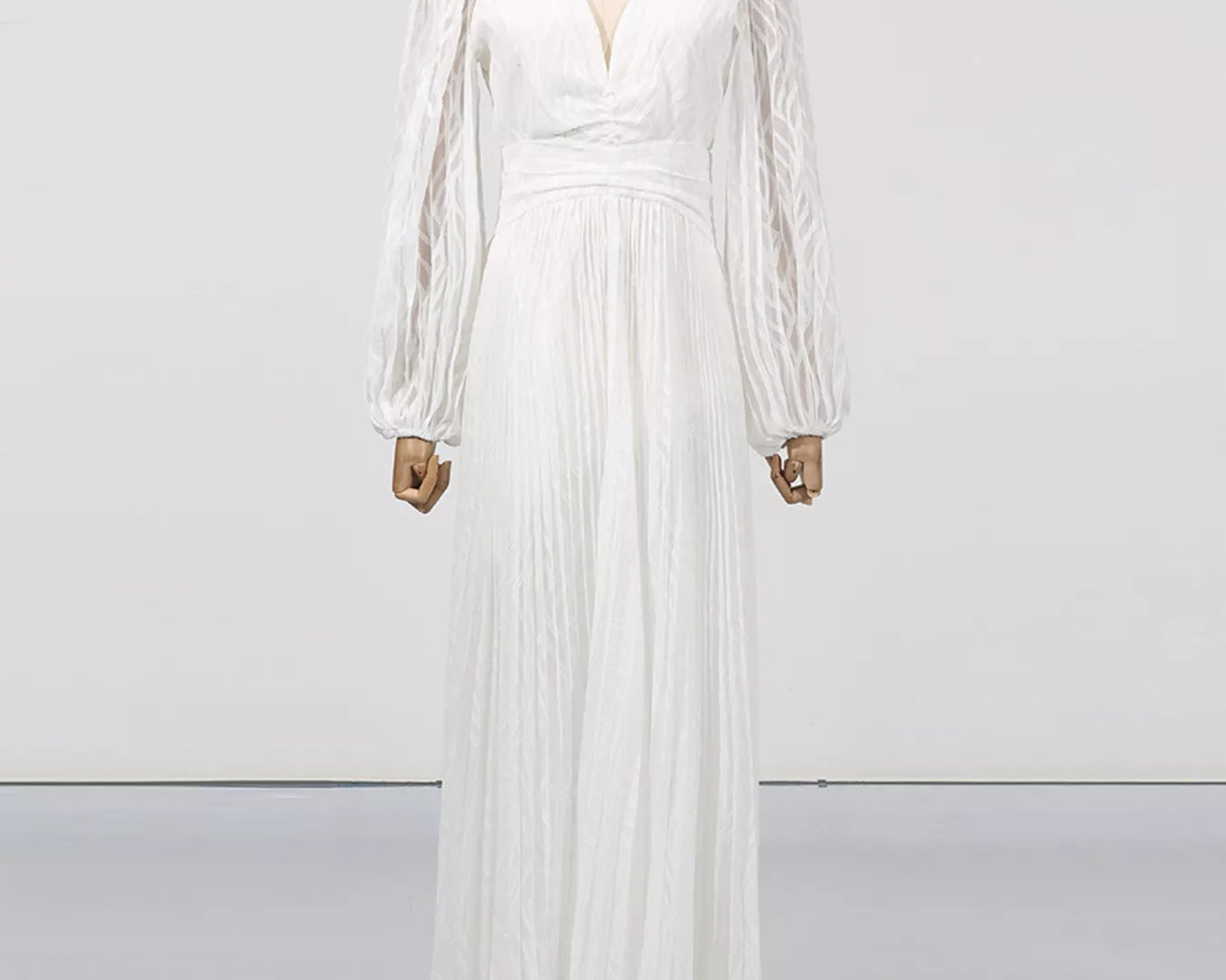 NEWYORKLISTED STYLE COLLECTION: White long-sleeve dress on a mannequin against a white background