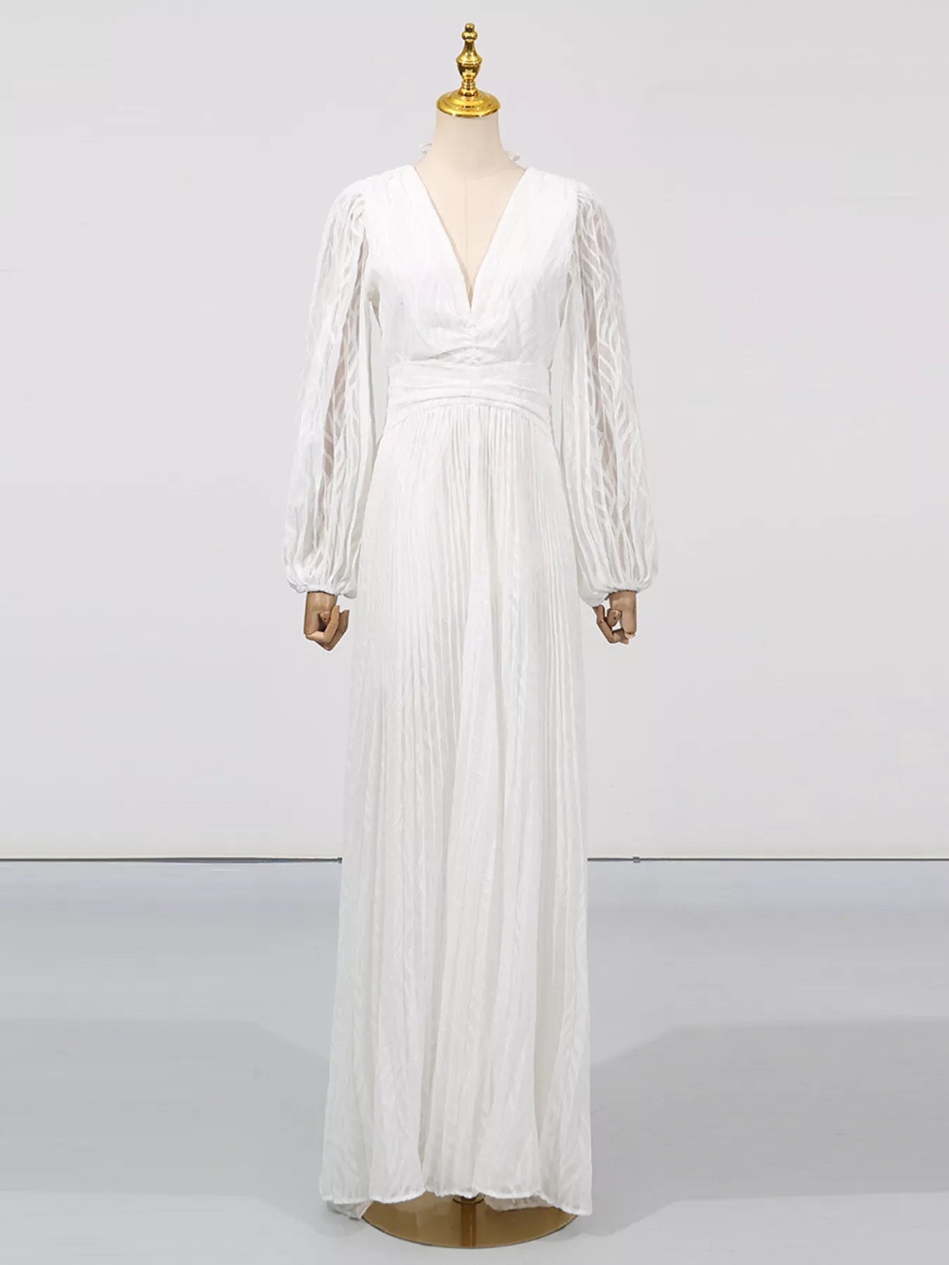 NEWYORKLISTED STYLE COLLECTION: White long-sleeve dress on a mannequin against a white background