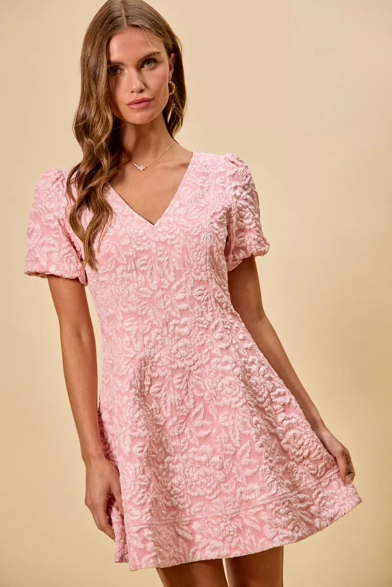 NEWYORKLISTED STYLE COLLECTION: Woman wearing a pink floral dress against a beige background