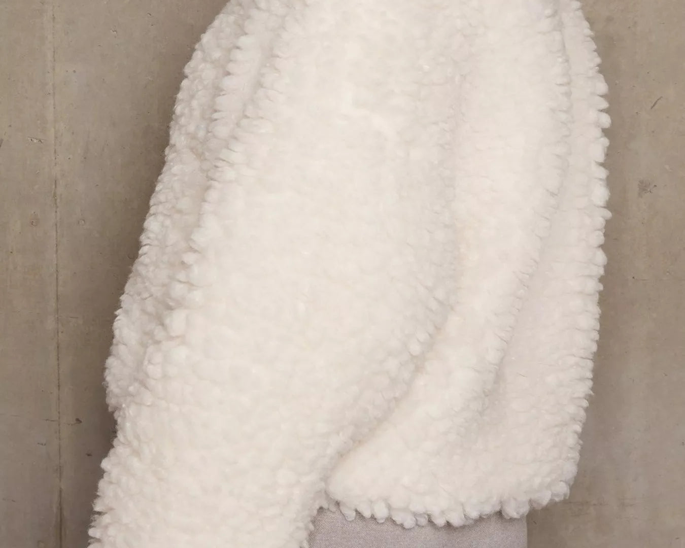 NEWYORKLISTED STYLE COLLECTION: White fluffy sweater over gray shorts against a neutral background