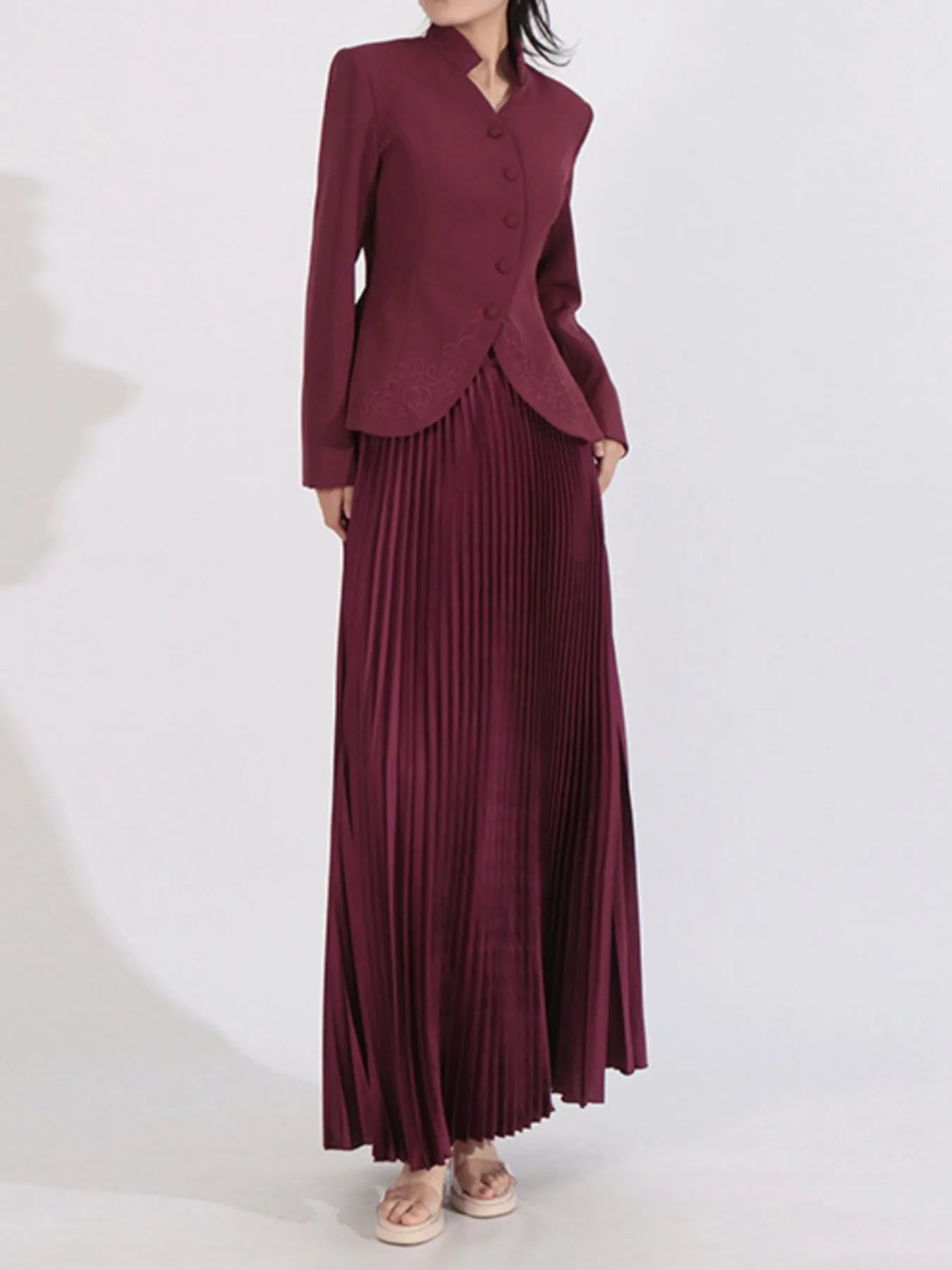 NEWYORKLISTED STYLE COLLECTION: Maroon suit with a jacket and pleated skirt on a white background