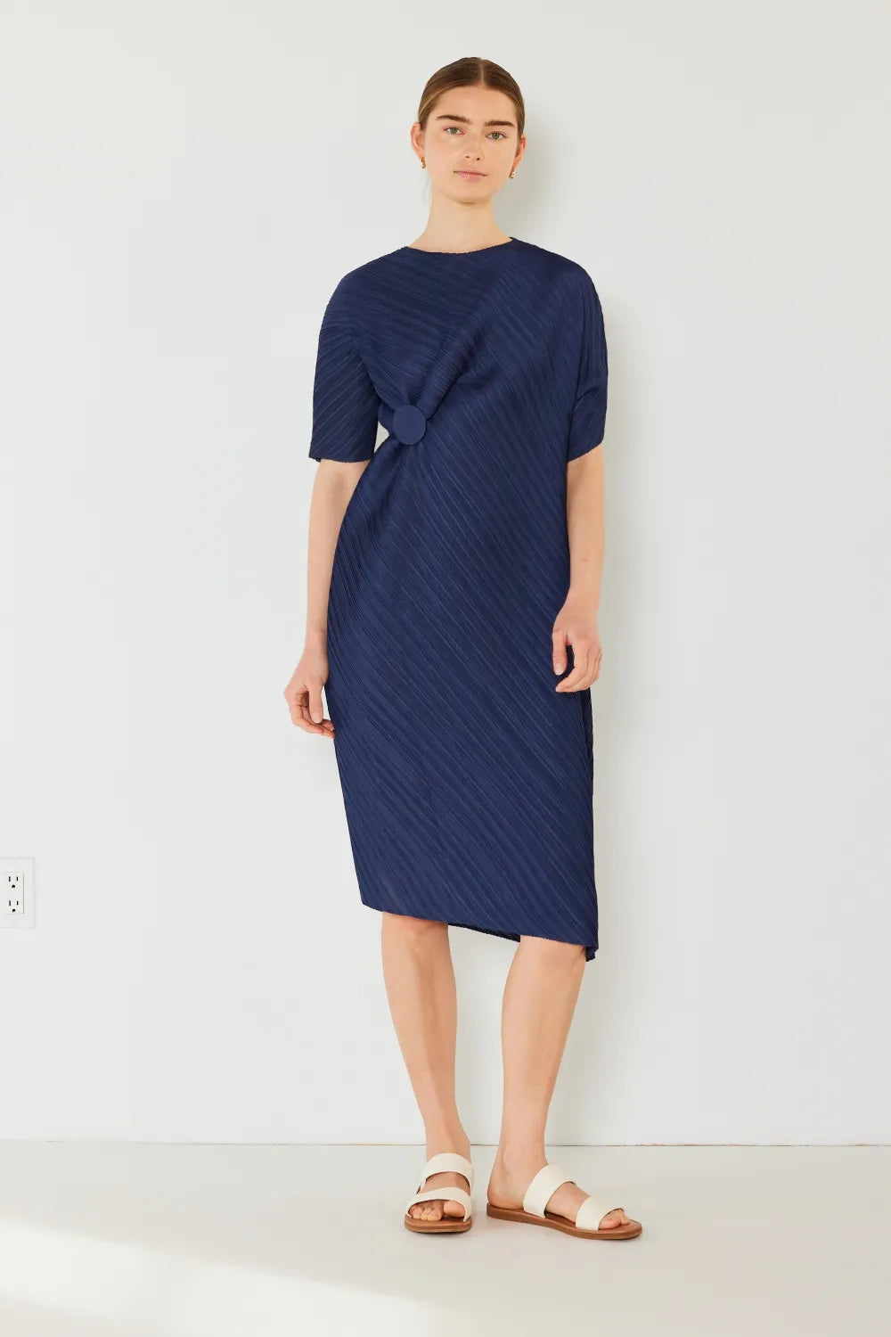 NEWYORKLISTED STYLE COLLECTION: Woman wearing a navy blue dress on a white background