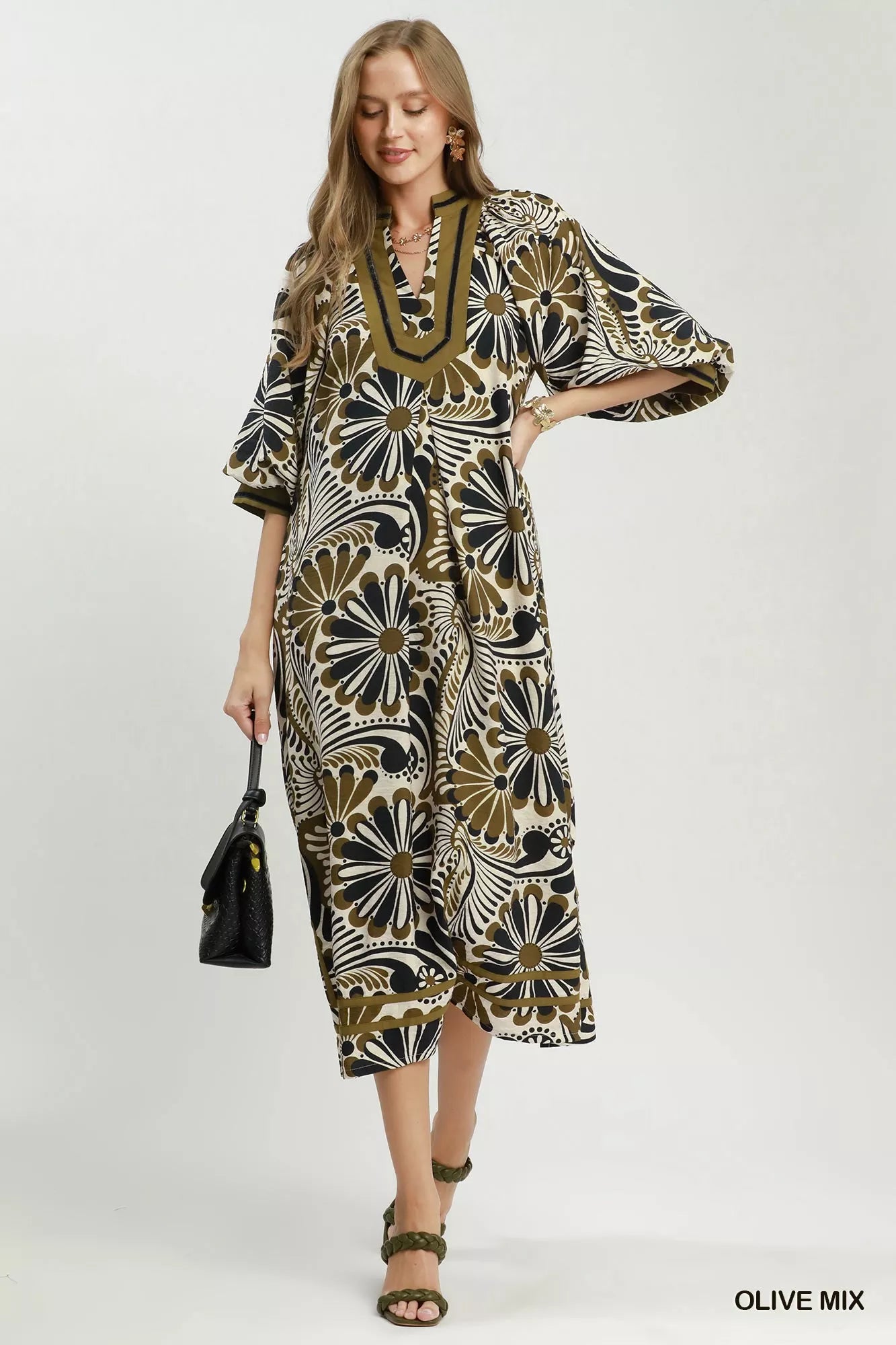 NEWYORKLISTED STYLE COLLECTION: Woman wearing a patterned dress with a white background