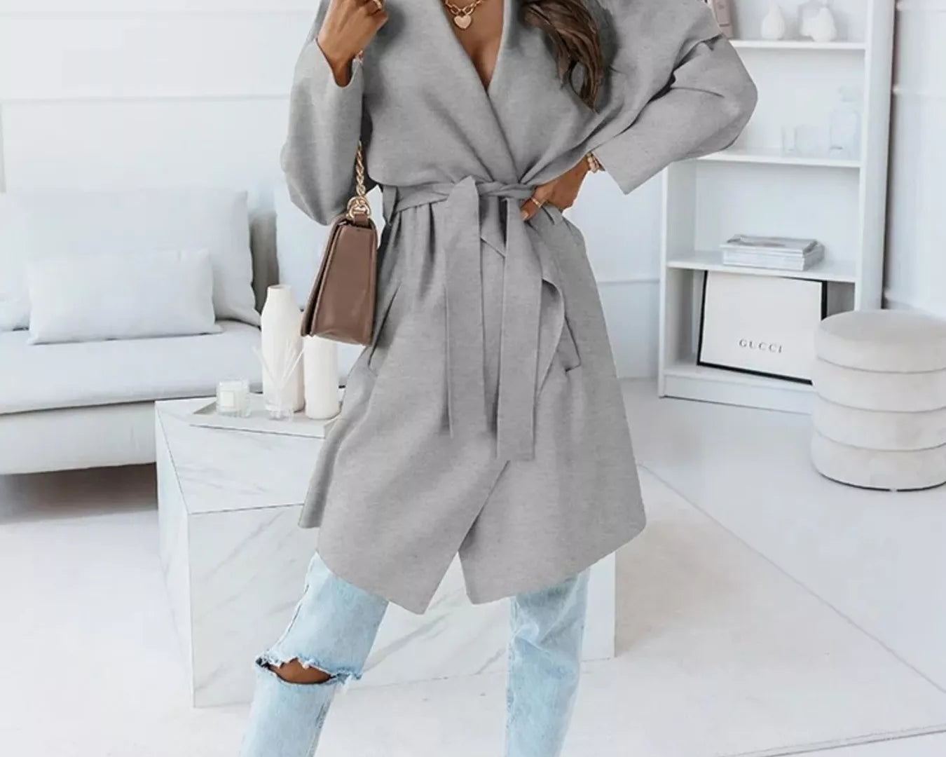 NEWYORKLISTED STYLE COLLECTION: Woman wearing a gray coat in a modern living room