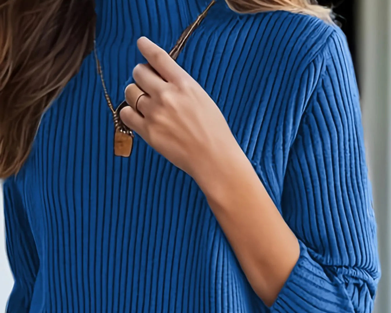 NEWYORKLISTED STYLE COLLECTION: Person wearing a blue ribbed sweater with a blurred background