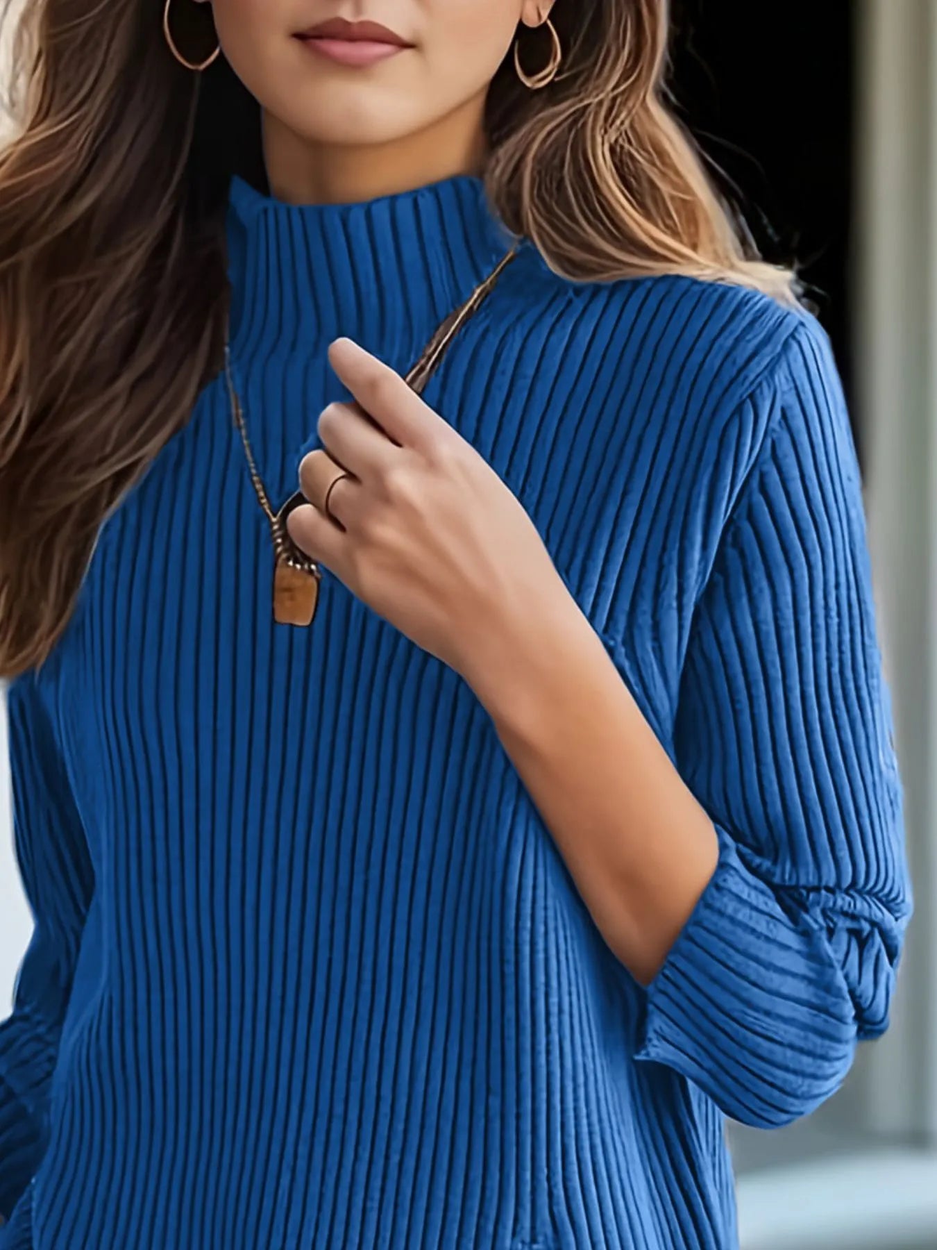 NEWYORKLISTED STYLE COLLECTION: Person wearing a blue ribbed sweater with a blurred background