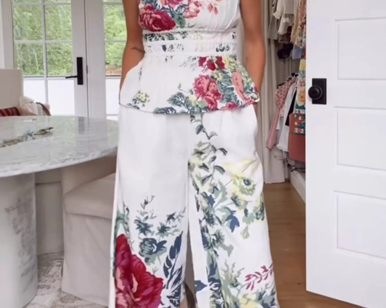 NEWYORKLISTED STYLE COLLECTION: Woman wearing a strapless floral top and wide-leg pants in a room with a desk and door.