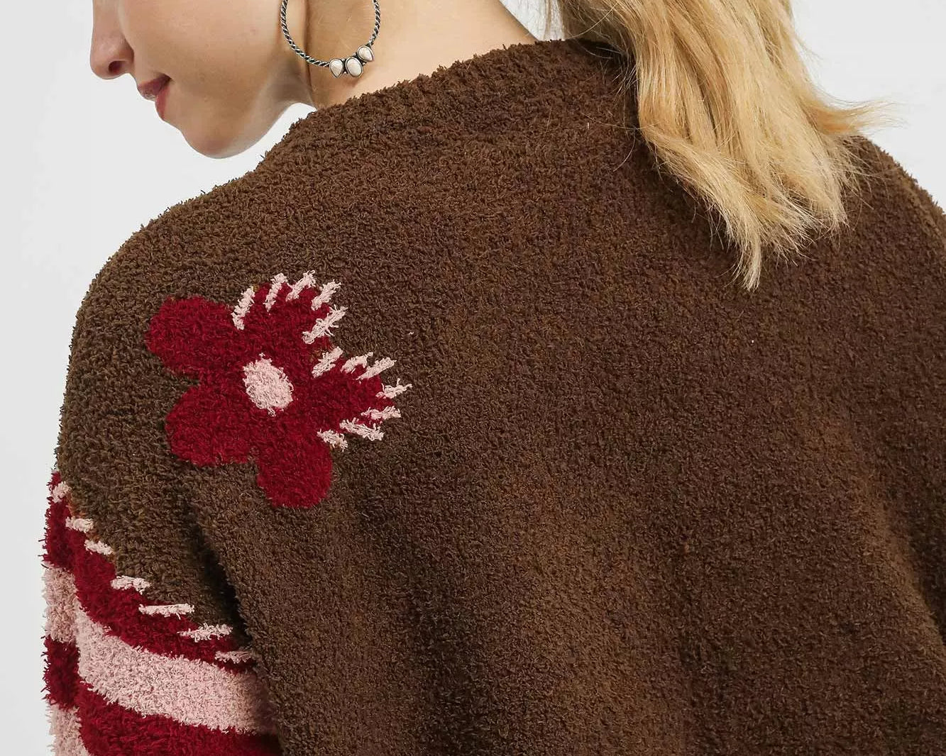 NEWYORKLISTED: Brown cardigan with red flower design on a plain background