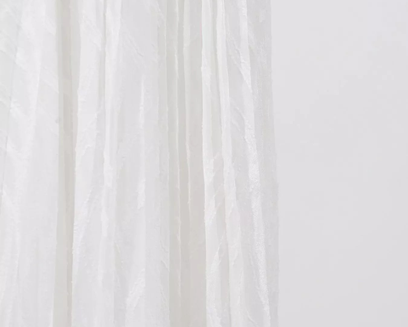 NEWYORKLISTED STYLE COLLECTION: Close-up of white fabric with a subtle pattern on a light background