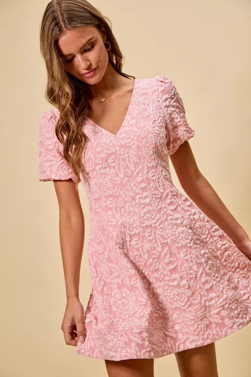NEWYORKLISTED STYLE COLLECTION: Woman wearing a pink floral dress against a beige background