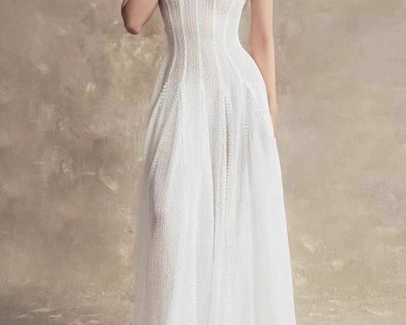 NEWYORKLISTED STYLE COLLECTION: Woman wearing a white dress against a textured beige wall