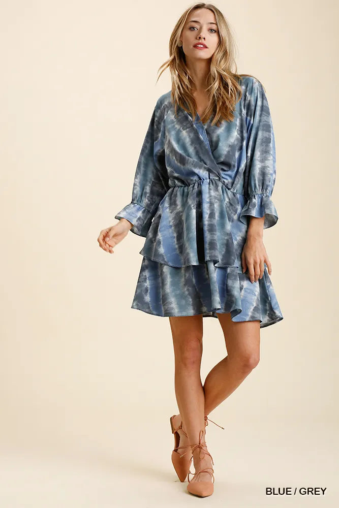 NEWYORKLISTED STYLE COLLECTION: Woman wearing a blue tie-dye dress on a beige background