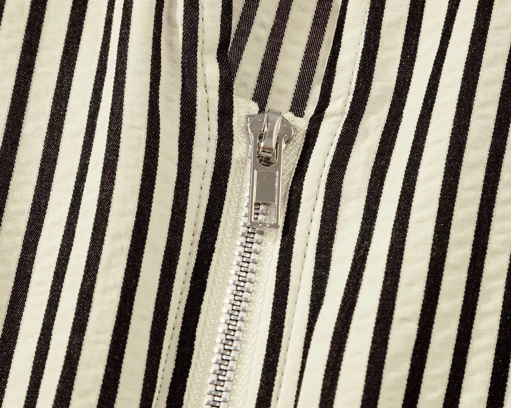 NEWYORKLISTED STYLE COLLECTION: Close-up of a black and white striped fabric with a zipper running vertically.