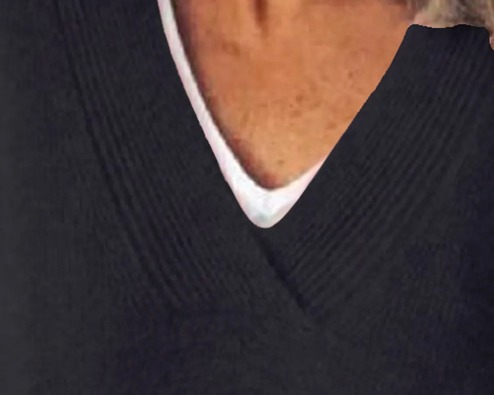 NEWYORKLISTED STYLE COLLECTION: Close-up of a person wearing a dark sweater with a white collar.