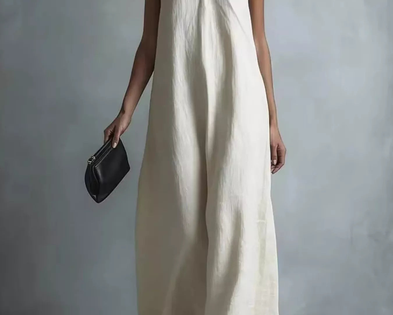 NEWYORKLISTED STYLE COLLECTION: Woman wearing a long white dress against a plain background