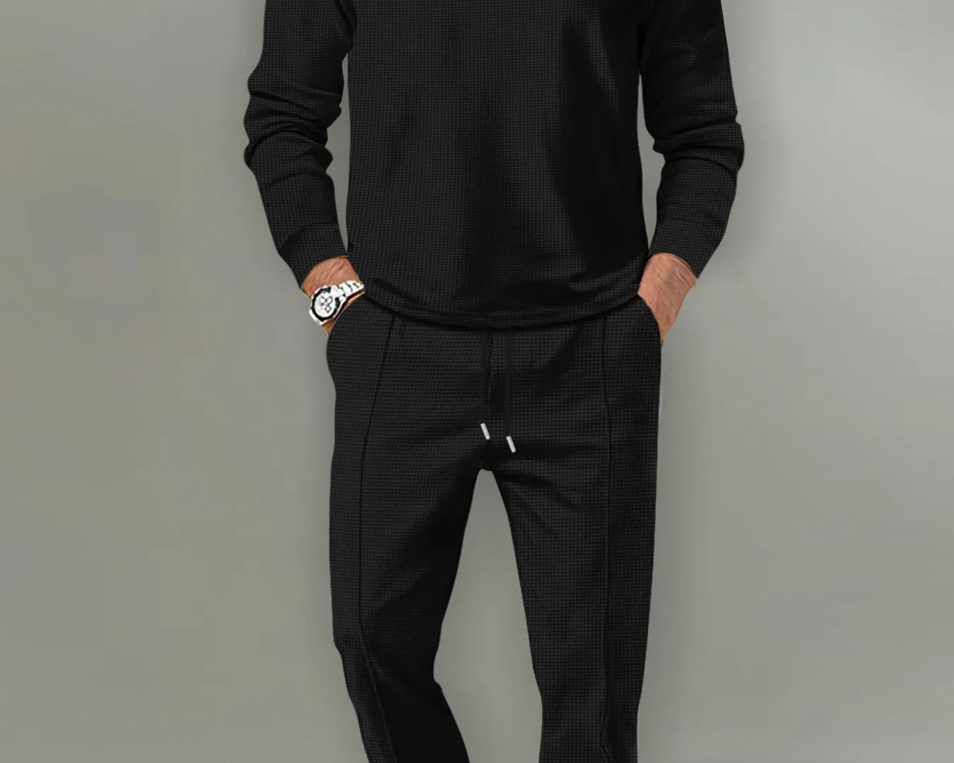 NEWYORKLISTED ATLAS MEN'S COLLECTION: Man wearing a black long-sleeve shirt and black pants against a gray background