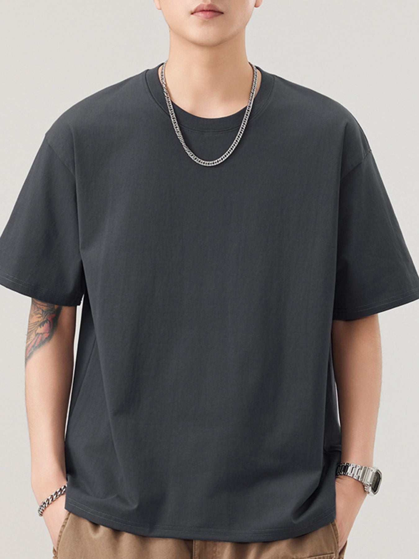 NEWYORKLISTED ATLAS MEN"S COLLECTION: Person wearing a black t-shirt and beige pants on a plain background