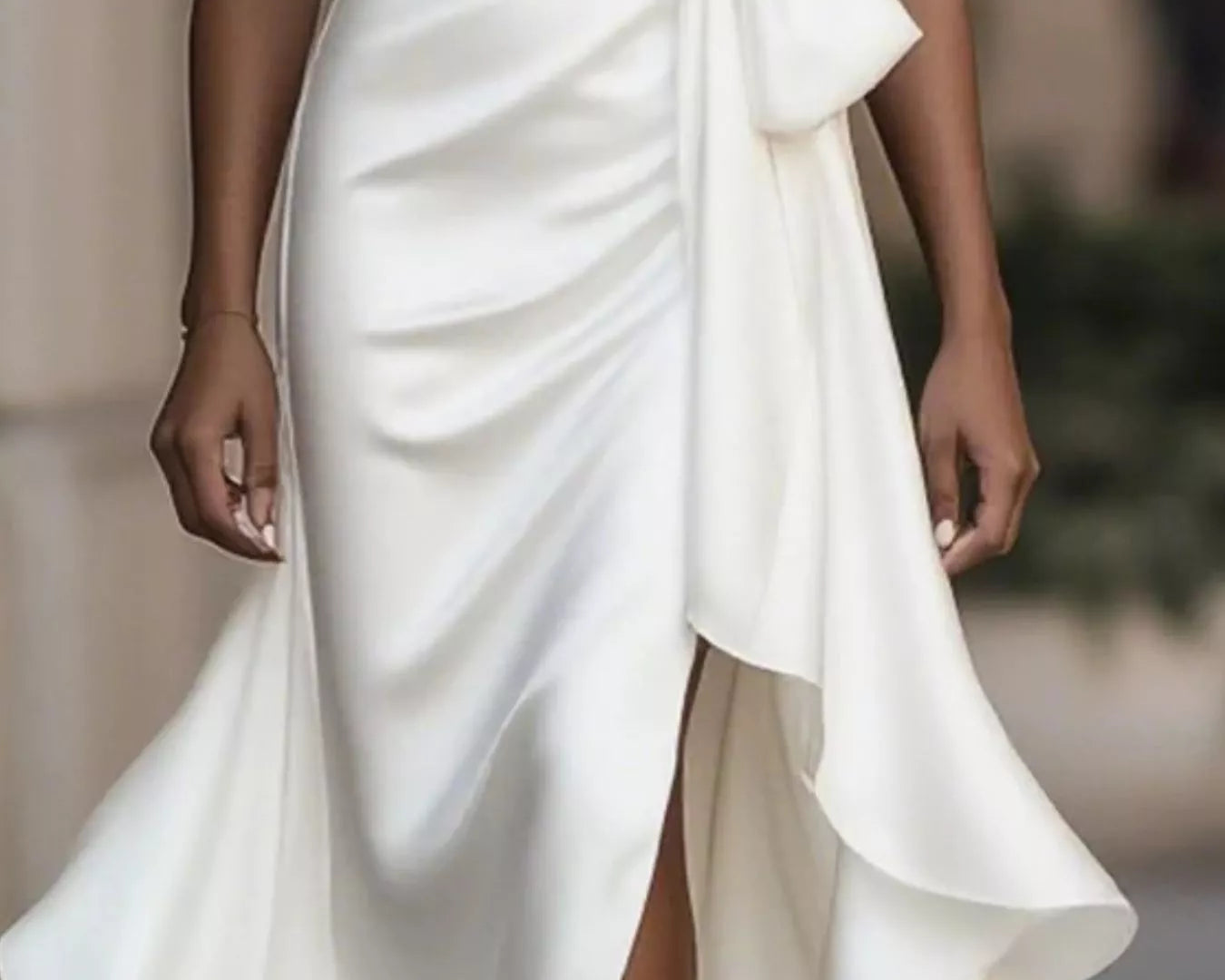 NEWYORKLISTED STYLE COLLECTION: White dress with a bow detail on a blurred background