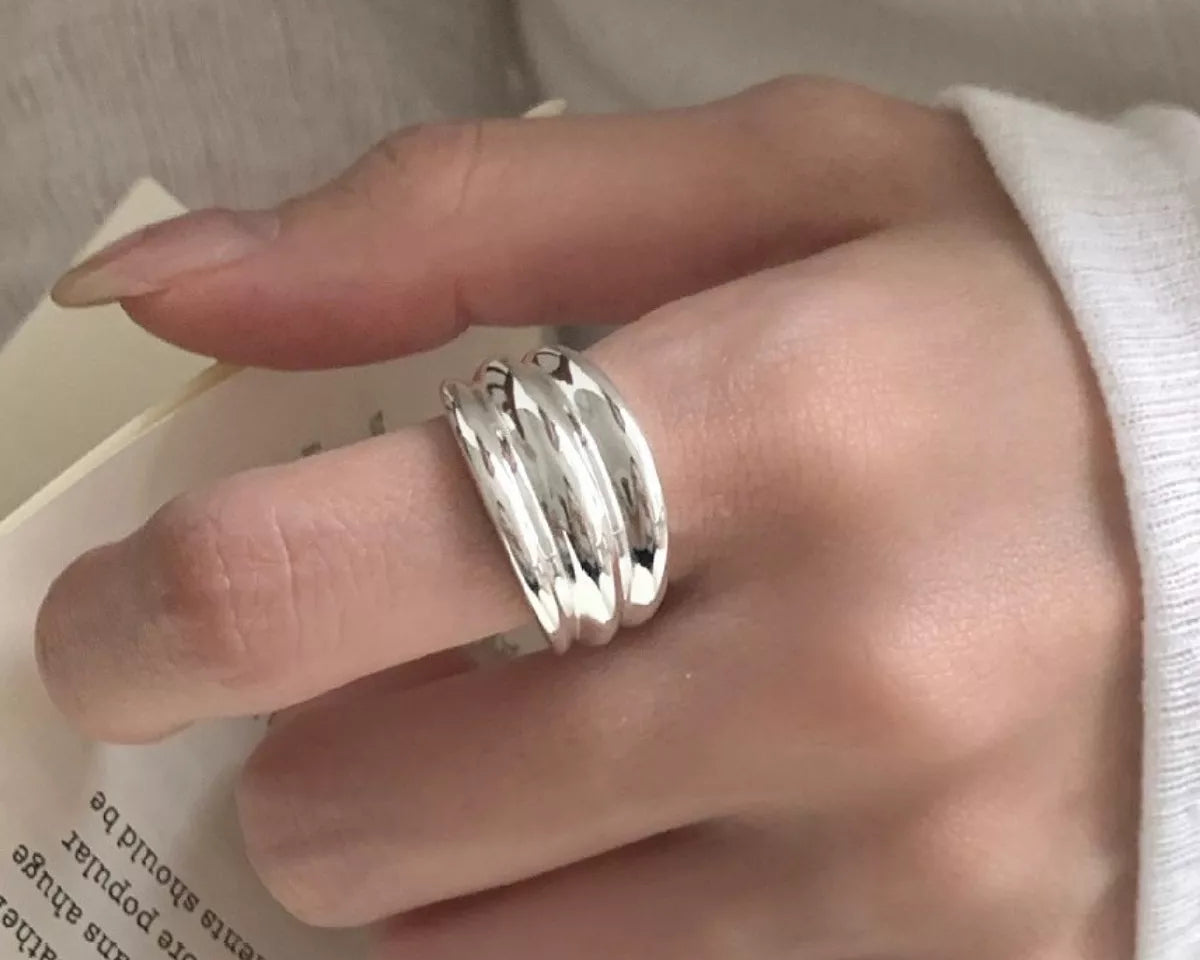 NYLD Glamour Collection: Hand wearing a silver ring on a light background