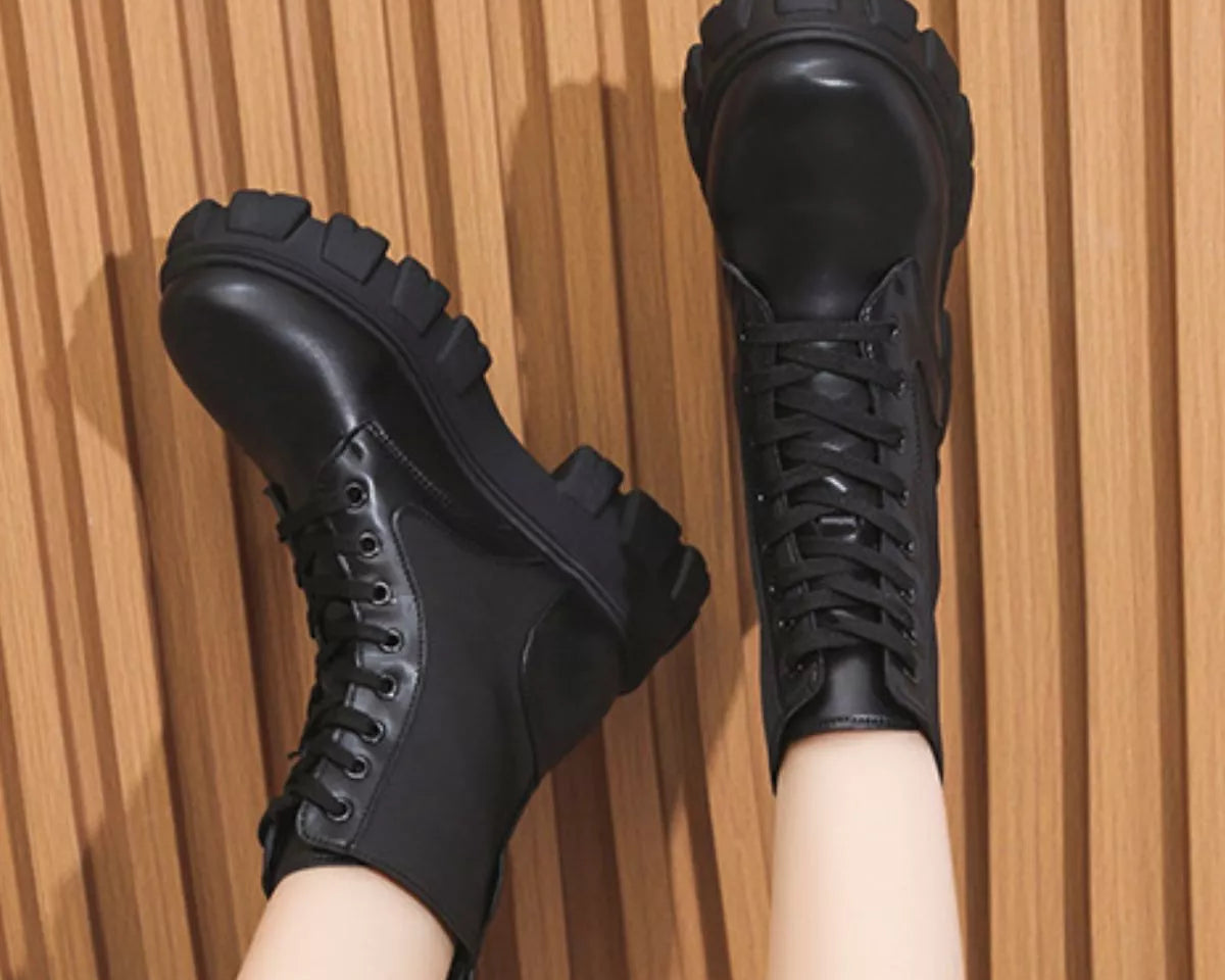 NEWYORKLISTED SHOE COLLECTION: Black lace-up boots on a wooden floor