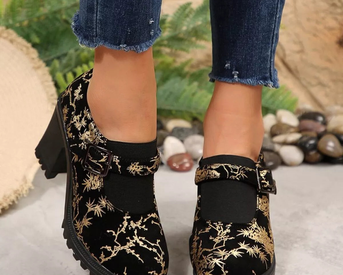 NEWYORKLISTED STYLE COLLECTION: Black floral embroidered boots worn with rolled-up jeans on a neutral background
