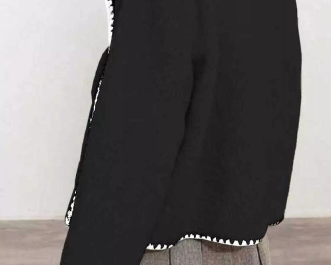 NEWYORKLISTED STYLE COLLECTION: Black jacket with white trim on a plain background