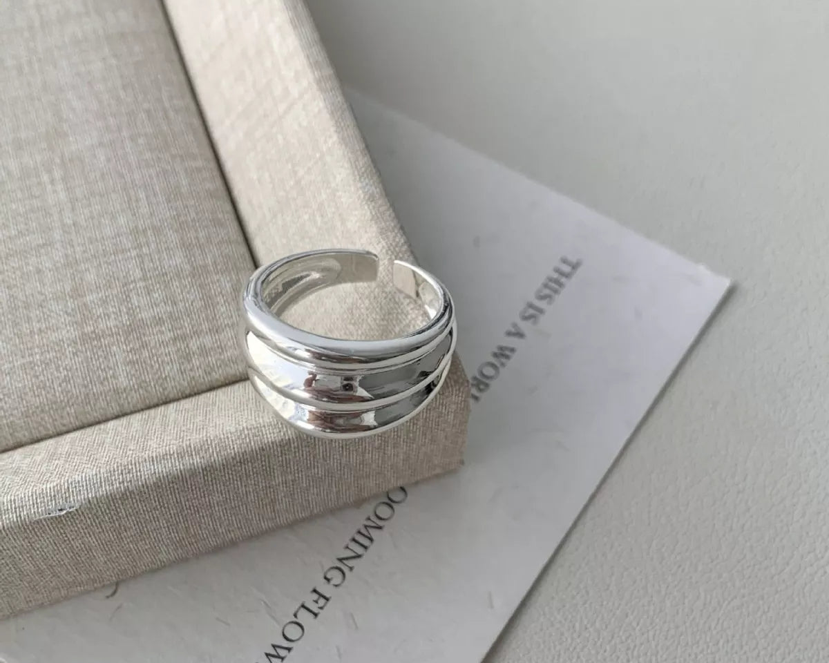 NYLD Glamour Collection: Silver ring on a textured surface with text in the background