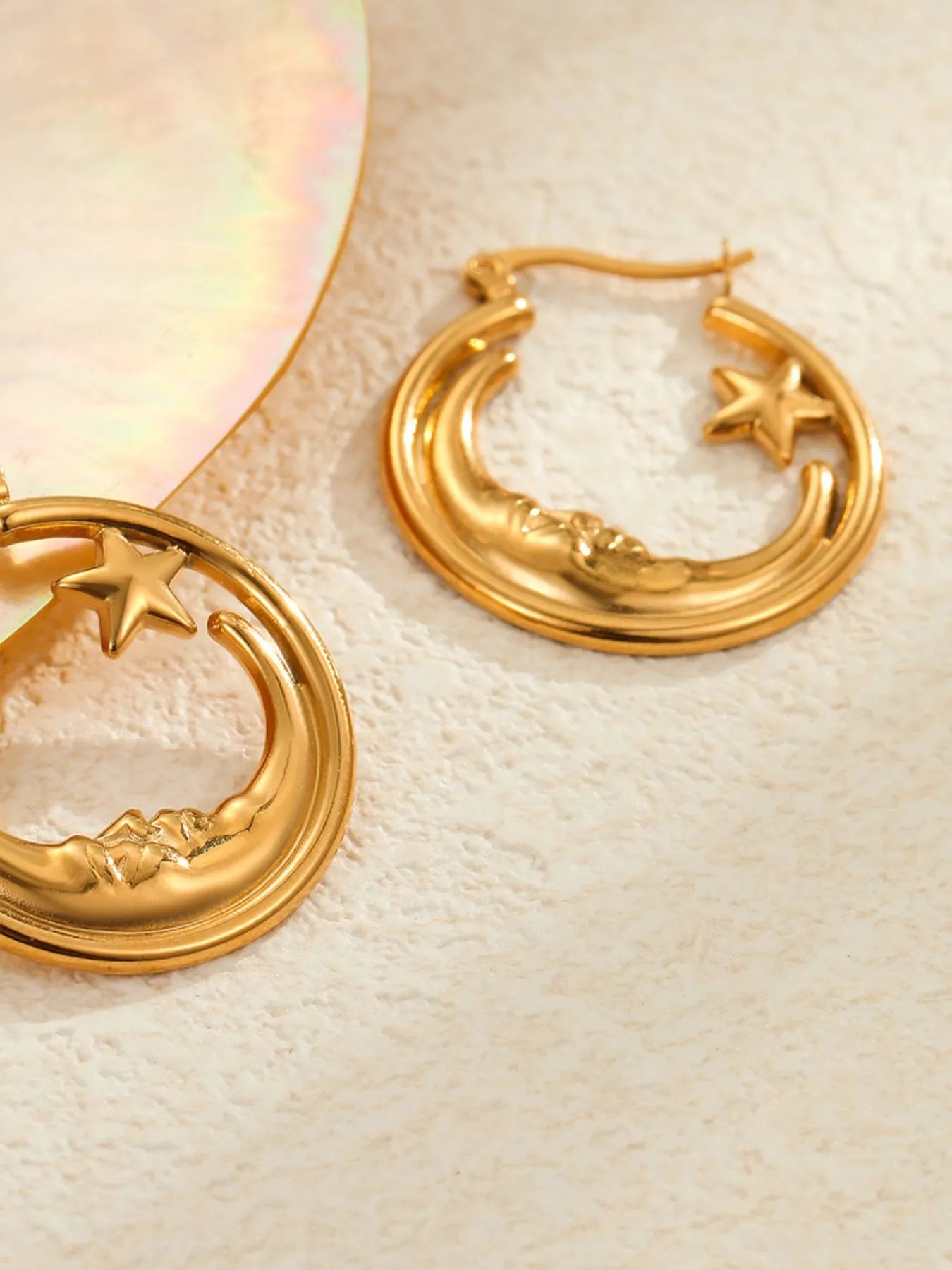 Gold hoop earrings with star and moon designs on a light background - NEWYORKLISTED STYE COLLECTION