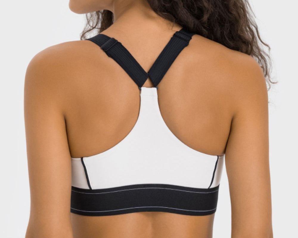NEWYORKLISTED ACTIVEWEAR COLLECTION: Person wearing a black and white sports bra on a plain background