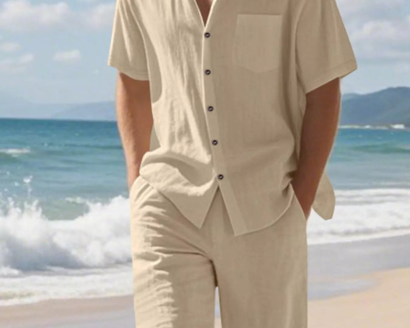 NEWYORKLISTED ATLAS MEN'S COLLECTION: Man wearing a beige outfit on a beach with ocean and sky in the background