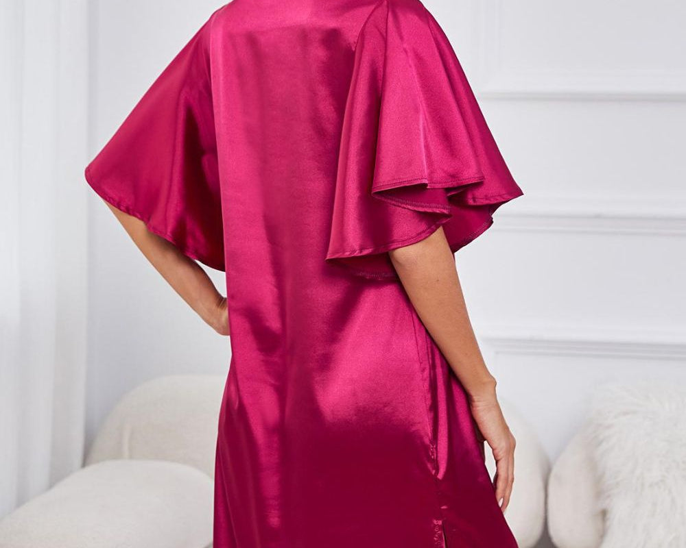 NEWYORKLISTED Intimate Apparel: Woman wearing a magenta satin dress with ruffled sleeves in a minimalistic room.