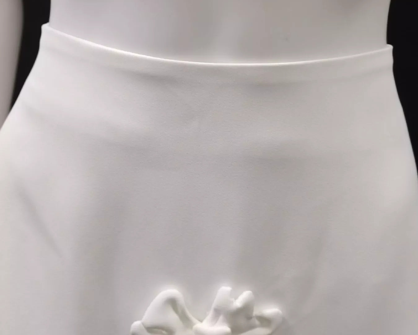 NEWYORKLISTED STYLE COLLECTION: White dress with a decorative floral brooch on a black background