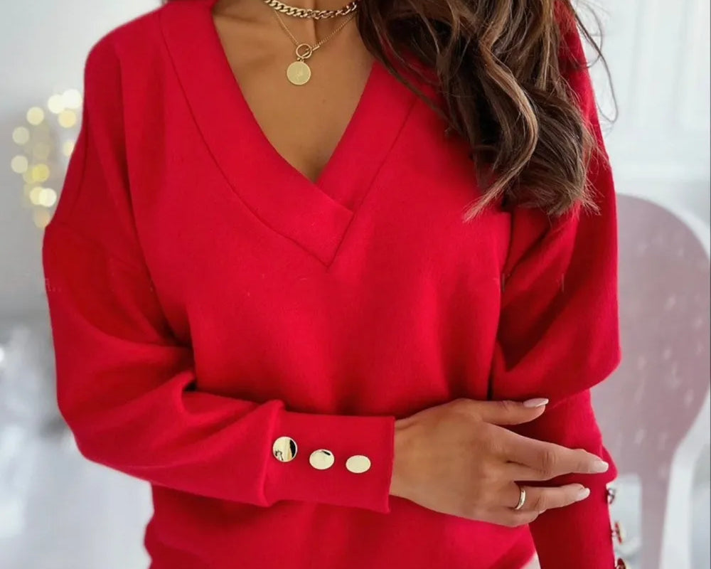 NEWYORKLISTED STYLE COLLECTION: Red blouse with gold buttons worn by a person, blurred background
